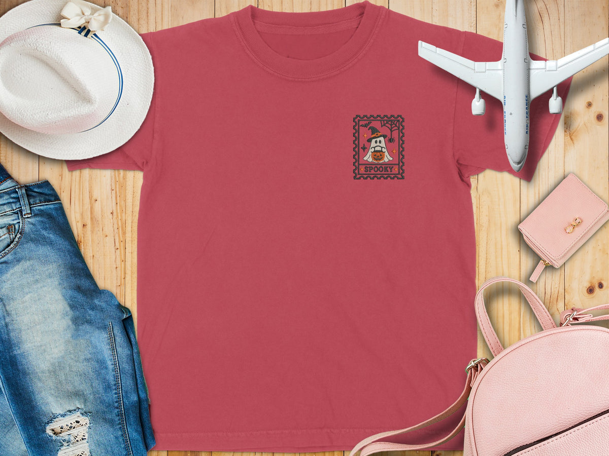 Red t-shirt with a ghost in a witch hat and pumpkin graphic, text "SPOOKY".